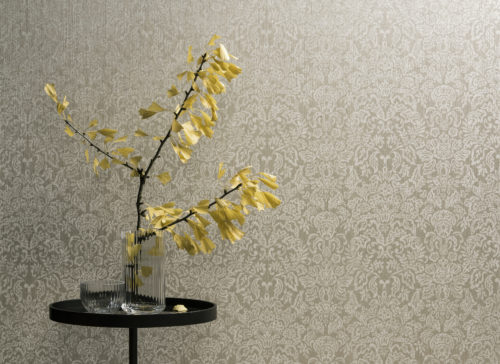 Damask wallcovering from the Omexco Elegance range. Round table with a ginko biloba branch in a glass vase.