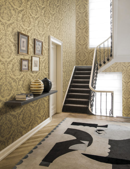 Impressive staircase with yellow and white gold damask wallcovering from the Omexco Elegance range. The contemporary abstract carpet on the wooden floor is in nice contrast with the classic design of the wallcovering