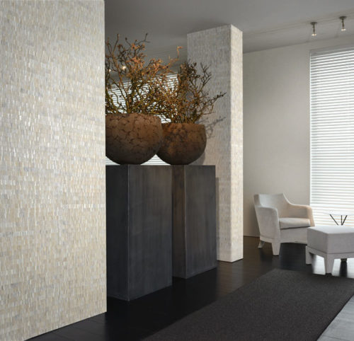 Waterlily leaves are woven in frozen white for this room. The matching non-woven wallcovering sometimes evoke arid textures of dry earth, swept by gusts of wind. In the middle of the room we see two large vases on pedestalls. In the back of the room a white lounging chair and stool.