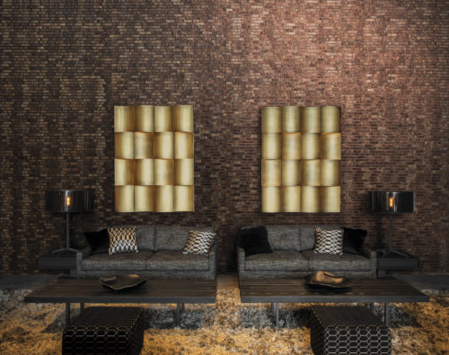 This living room showcases our metalized woven bakbak strips wallcovering in dark brown and copper: regular and fine strips of bakbak are sewn together with metallic threads of shimmering copper to create an air of total elegance.