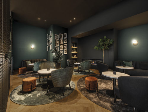 On the walls of this cosy, luxury hotel lounge: the Linen design in duck green and dark grey from Omexco's High Performance Textures collection.