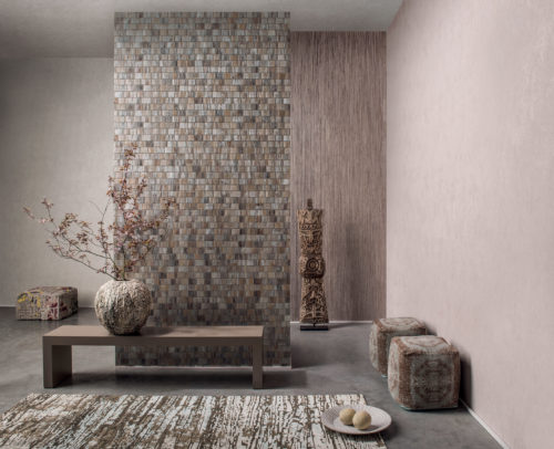 Ethnic interior in sand tones. Pixelated pouf, totem, carpet fabric poofs, structured vase with branch of blossoms.