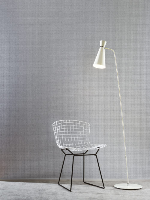 For this mica wallcovering in the Graphite range we've embossed grey mica with a silver foil in the form of little blocks. It goes well with other geometrical interior details like this white standing lamp and white wire chair.