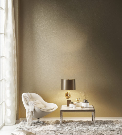 Stunning mica shells wallcovering. Mother of pearl in old gold reflecting the light from a lamp with brown shade. Contemporary white lounge chair, curtain with large dots and plush carpet.