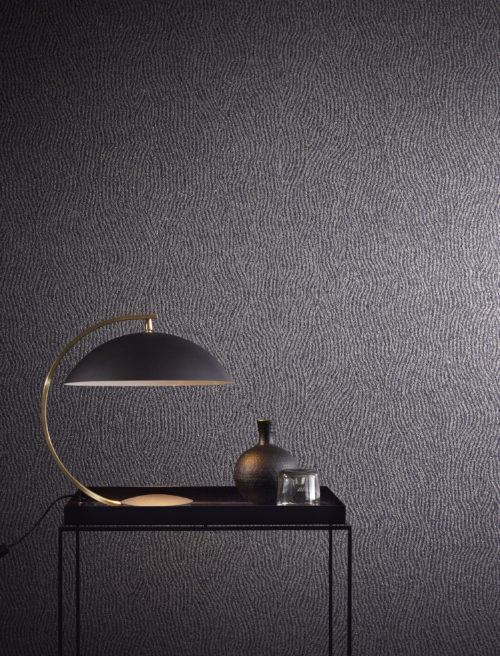The mica wallcovering in this picture is printed with a weavy geometrical pattern. It's combined in this interior with a geometrical black lamp and vase.