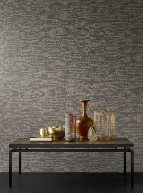 As if it is a still life painting, Graphite wallcovering is combined here with a table filled with different vases in copper and gold. The mica wallcovering is printed with a weavy line.