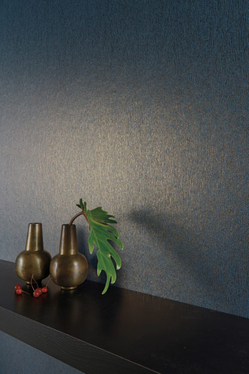 Impressive dark bleu wallcovering with golden foil delicate stripes. Two brown vases and cherries on a shelf.