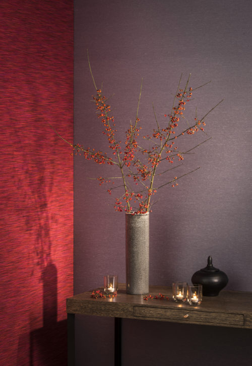 Warm setting with a grey vase with berries, candles, purple and bright red Elegance wallcovering.