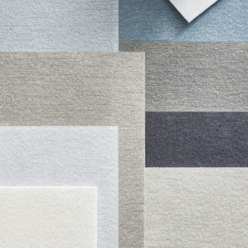 An image of wallcovering samples in shades of white, beige, light blue and anthracite from Omexco's acoustic collection Silence. This is Omexco's first collection of decorative wallcoverings with acoustic properties.