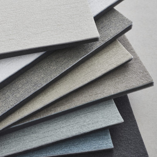 An image of wallcovering samples in shades of white, beige, light blue and anthracite from Omexco's acoustic collection Silence. Silence is a high-quality product with a simple tone-on-tone design. The design is available in a subtle range of 10 colours.