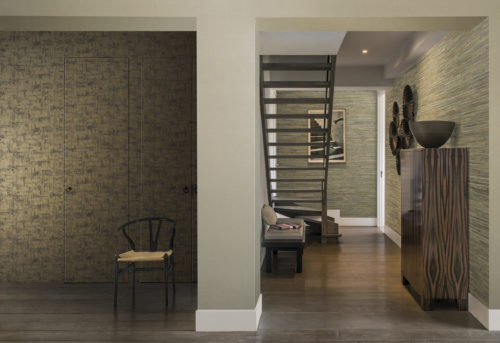 Living space with tropical wood side board. Black chair with yellow pillow. Omexco Aruba wallcovering hides the doors. On the far and right wall waterlily give the room the finishing touch.