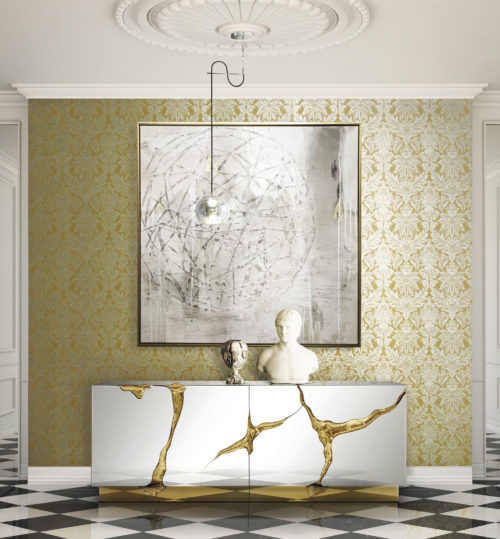Yellow wall with silver damask, impressive shiny console with gold cracks, buste, pending lamp, silver painting. White and black checked floor.