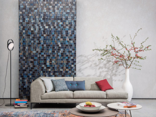 Well balanced decor with bakbak Borneo wallcovering, sofa with blue and red pillows. White vase with blossoming branches. Two round coffee tables. Carpet with red and blue hints.