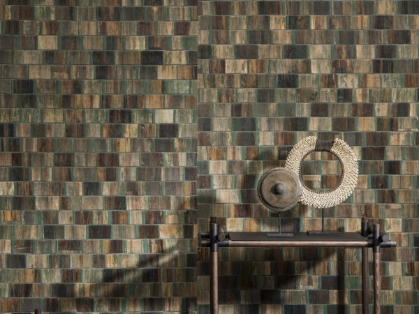 Detail of green and brown bakbak wallcovering. Rotan shelves with two round artworks.