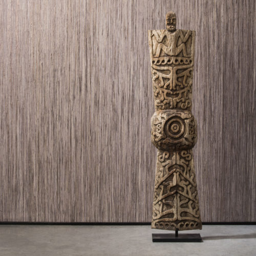 Detail of Borneo raffia wallcovering with wooden totem. The wallcovering is installed vertically.