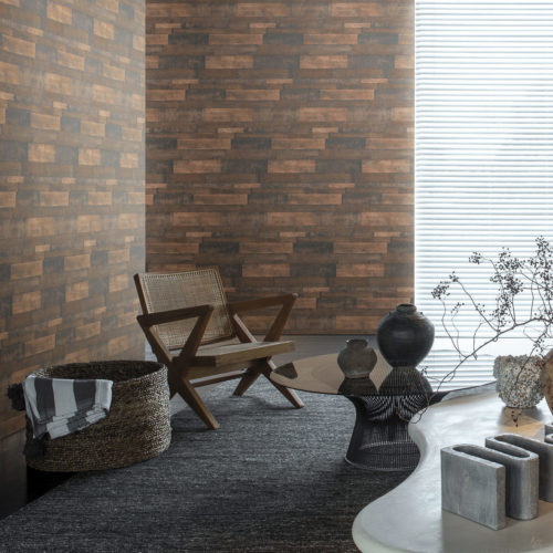 Impressive interior with ethnic details. On the walls: a horizontally installed wallcovering from our Loft collection. The walls look like oxidised metal. We see a wooden chair and woven basked.