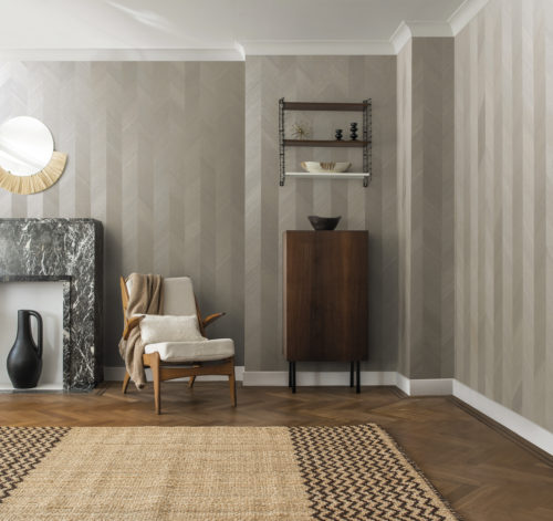 Our silver coloured chevron in real wood veneer is shown in an interior with other wood details. Rich tonal variations reveal the delicate wood grain of the Paulownia tree. Luxurious and sensual to the hand and to the eye. This is an exclusive wallcovering from the Sycamore collection by Omexco.