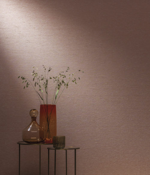 Pink Omexco wallcoverings, shown horizontally. Tables with iron base and antique finished mirror. Red vase with springy plants.