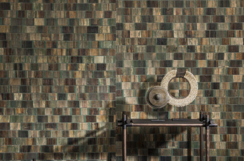 Detail of green and brown bakbak wallcovering. Rotan shelves with two round artworks.