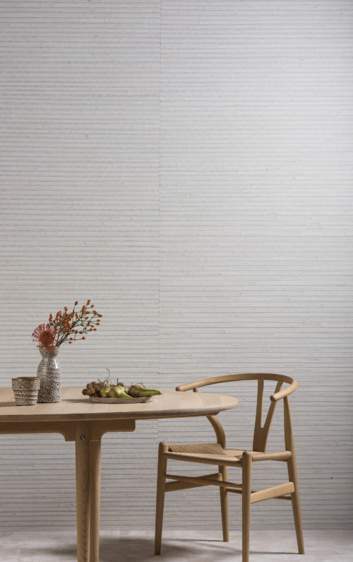 Wooden table and Wegner wishbone chair. Jute and grass wallcovering.