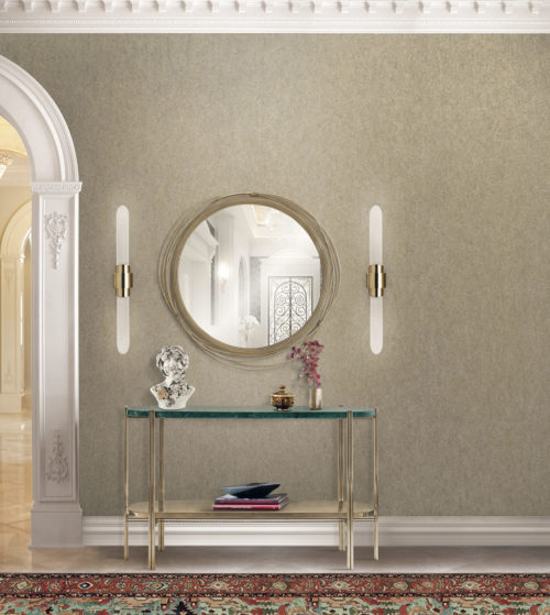 Wall in a hallway with mirror and two lamps on each side of the mirror. The mirror is decorated with cables. Console in glass and gold metal. Buste.