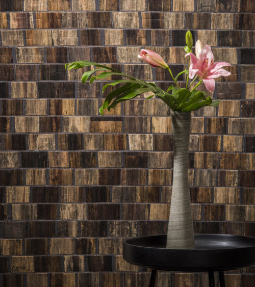 Detail of Borneo bakbak wallcovering with round table, beige vase with pink flowers.