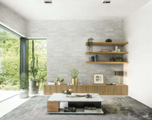 Imagine discovering a haven of peace in the midst of he wild energy of the city. The Omexco Loft collection was inspired by wall patinas weathered by the depths of history. In this interior we see the wallcovering combined with a marble table, wooden sideboard and a collection of rare plants. On the lefthand side a large window with view on the garden.