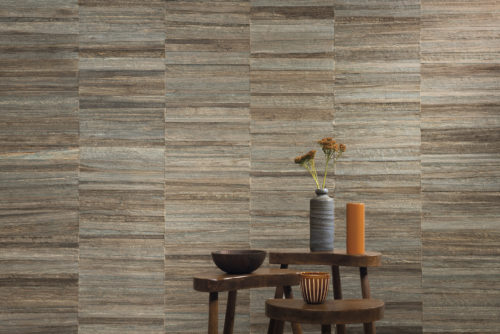 The Atelier wallcovering collection by Omexco is a tactile tribute to the importance of handmade craft in interior design. Here we see a brown grey striped collage made from banana bark, wich is the perfect backdrop for the three wooden side tables and other natural decorative elements. If you are looking for a boho chic home decor with rich organic textures, you will definitely feel inspired by this image!