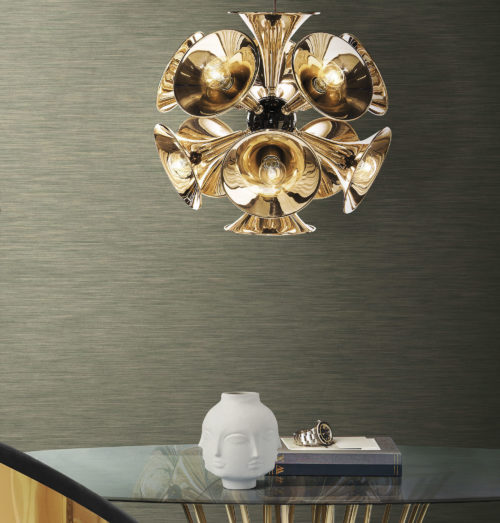 Round glass table with slim wooden legs. Porcelain vase with heads. Outstanding golden lamp. Inifnity wallcoverings.