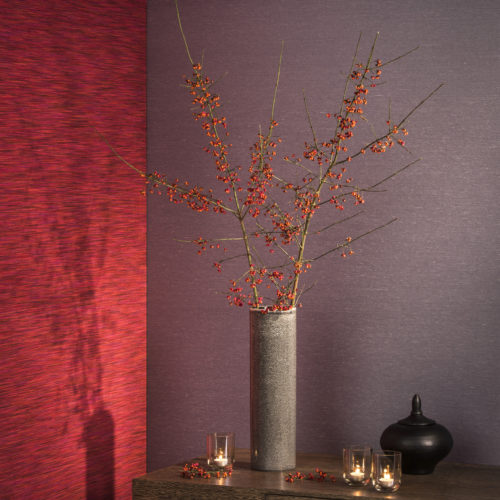 Warm setting with a grey vase with berries, candles, purple and bright red Elegance wallcovering.