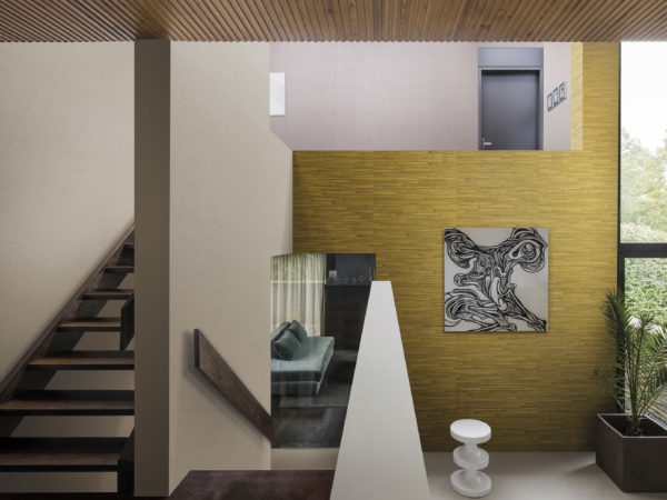 Staircase in a contemporary home. Eyecatching yellow Aruba wallcovering in banana yellow. Black-and-white work of art.