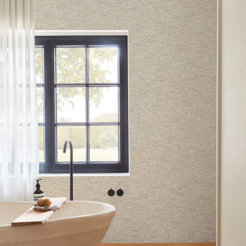 Example of a rustic modern bathroom with a freestanding bathtub, black taps, a window with garden view medium tone parquet floor. On the wall we see Omexco’s Belgian linen wallcoverings in off-white and light grey hues. Woven using the finest natural fibres and expert craftsmanship, each design of Omexco’s "Loom Stories" collection demonstrates its design studio’s commitment to create refinement and design elegance.