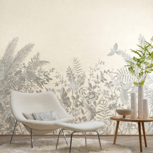 Living room with a light herringbone floor and a round, off-white rug, a white soft single seater with a foot stool and a wooden side table on which three organic shaped vases and a bowl are placed. But the true eyecatcher of the room are Omexco’s tropical "Birds of Paradise" wallcoverings. The design consists of tropical plants and flowers, parrots and other exotic birds, printed in light grey on a beige background. The design is inspired by the work of the French zoologist Jacques Barraband.