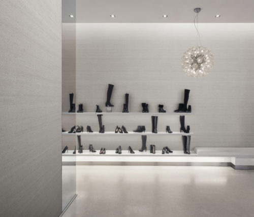 A contemporary, luxury shoe store with black boots and heels displayed against the wall. The perfect backdrop for the beige texture of the Tussah design of Omexco’s High Performance Textures wallcoverings. Function meets beauty, durability meets luxury, sustainability meets high performance.