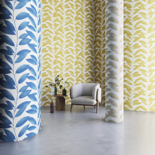 This image shows the Blooming Marvellous design from Omexco's wallcoverings collection Joy. A graphic pattern of stylized leaves in shades of blue, yellow and beige. Printed on 100% recycled fibres, reflecting Omexco's long tradition of sustainable sourcing of materials, the Joy Collection goes even further in the brand's ecological aspirations.