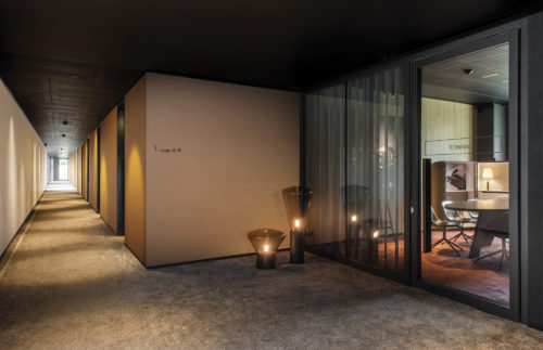 This picture shows just how timeless and elegant our Silky design from our eco-conscious High Performance Textures collection is. We see a hotel hallway with beige and orange walls. We suggest a railroad hanging here. It reminds us of very fine textile warps (fil à fil) Omexco is famous for, and which has this silky shimmer. It is printed on a nonwoven with a structure that is similar to an embossing.