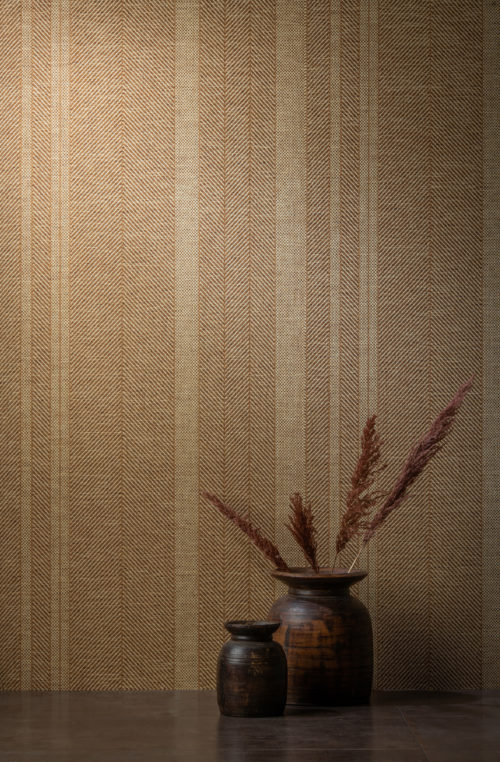 A closeup of Omexco's paperweave collection Tribu. The design we see here is a stunning rhythmic stripe. The perfect backdrop for the contemporary ceramic vases and decorative feathers in the foreground.