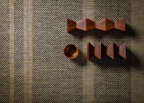 A closeup of Omexco's paperweave collection Tribu. The design we see here is a stunning rhythmic stripe. Wooden decorative elements were added to create an interesting setting.