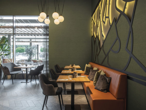Image displaying Omexco's High Performance Textures wallcovering. 'Abaca' is the name of the design. The green non-woven wallcoverings are shown horizontally on the walls of this contemporary restaurant.