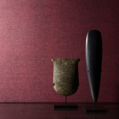 Red non-woven wallcovering on the wall. It looks like sisal wallcovering, but with better technical properties. Two african statues.