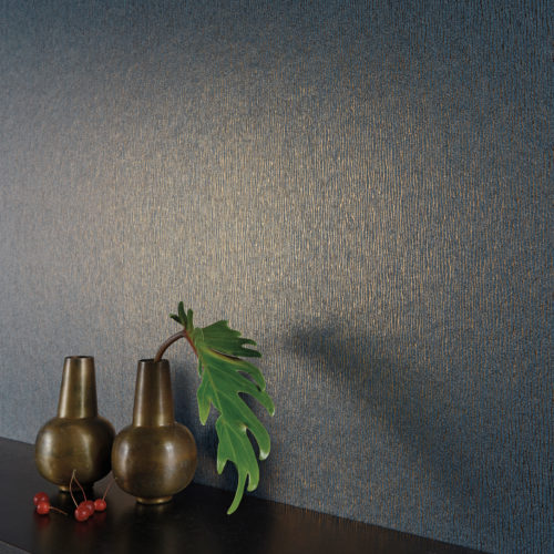 Impressive dark bleu wallcovering with golden foil delicate stripes. Two brown vases and cherries on a shelf.