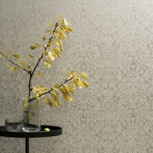 Damask wallcovering from the Omexco Elegance range. Round table with a ginko biloba branch in a glass vase.