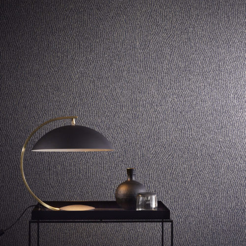 The mica wallcovering in this picture is printed with a weavy geometrical pattern. It's combined in this interior with a geometrical black lamp and vase.