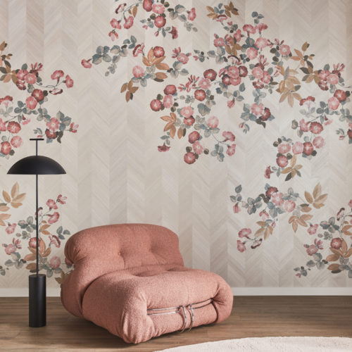 A tastefully arranged decor shot featuring a sleek black floor lamp positioned beside a soft and comfortable pink single seater on a parquet floor. A beige round carpet lies in front of the furniture, complementing the warm tones. In the background, Omexco’s wood marquetry collection “Imperialis” adds an elegant touch with its exquisite floral design printed on a beige chevron base.