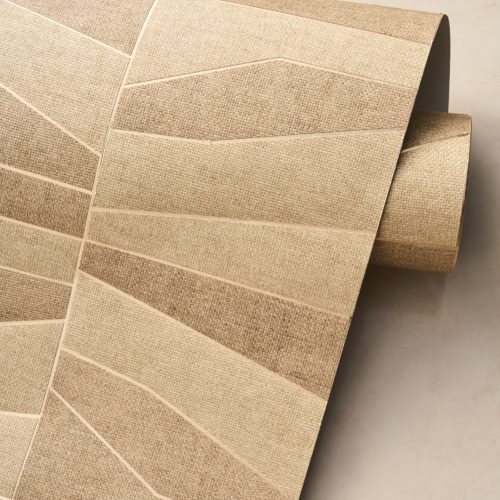 A close-up of an unrolled wallpaper roll from the Oase collection, featuring the OAS231 reference, Domino. This design showcases a patchwork of paperweave, meticulously crafted from geometric shapes that create a dynamic visual effect. The structured pattern rests upon a metallic backing, available in gold or silver, adding a subtle shimmer and depth to the texture. The neutral, earthy tones highlight the natural beauty of the material, enhancing the organic aesthetic of the composition.