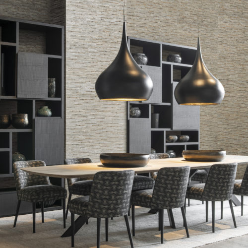 If we desire an interior space that honours our authentic personality and becomes a personal sanctuary providing peace and wellbeing, Seraya is our natural choice... In this picture we see a dining room with black cabinets. On the walls: woven rattan & bacnoc, a unison of two fibres - the bacnoc knots are intertwined with the rippled rattan fibres - creating a perfect decorative harmony.