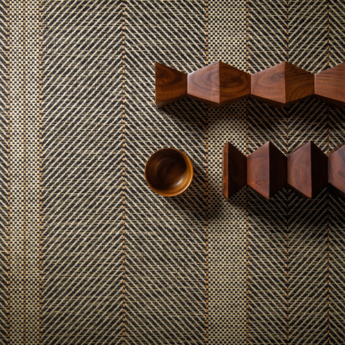 A closeup of Omexco's paperweave collection Tribu. The design we see here is a stunning rhythmic stripe. Wooden decorative elements were added to create an interesting setting.