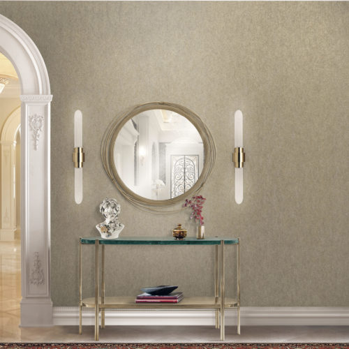 Wall in a hallway with mirror and two lamps on each side of the mirror. The mirror is decorated with cables. Console in glass and gold metal. Buste.