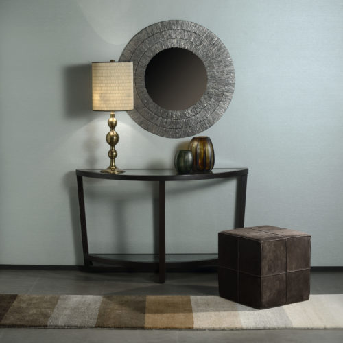 Peaceful decor with round mirror, leather poof and golden lamp. Behind it: light blue Infinity wallcoverings.