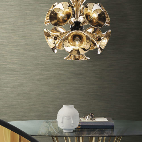 Round glass table with slim wooden legs. Porcelain vase with heads. Outstanding golden lamp. Inifnity wallcoverings.